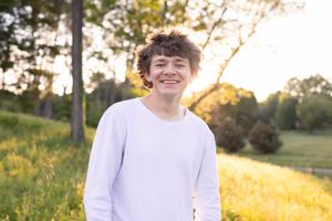 Senior photo in Charlottesville, VA at golden hour with the sunset in the background.