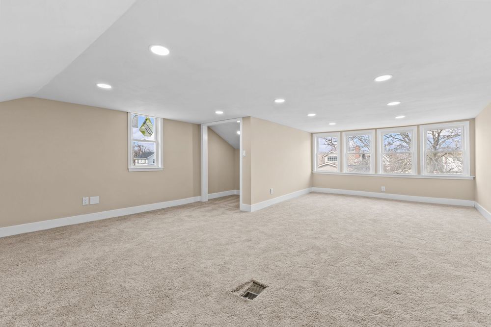 Spacious carpeted basement with recessed lighting, neutral beige walls, and multiple windows allowing natural light. Detroit Michigan