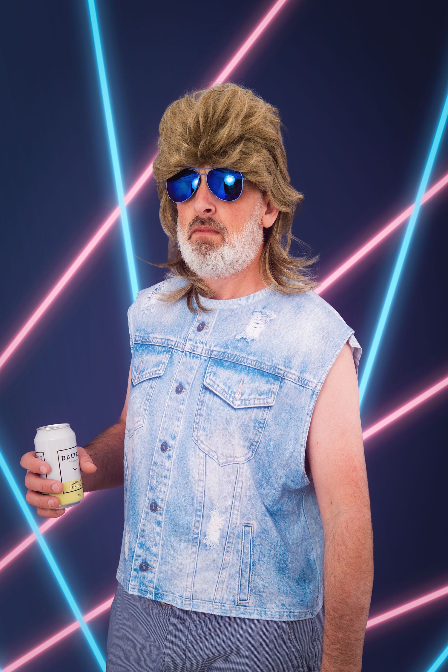 Awkward 80's photo of a man with a mullet, wearing cheesy denim, with a beer in hand. photo taken against a neon laser backdrop