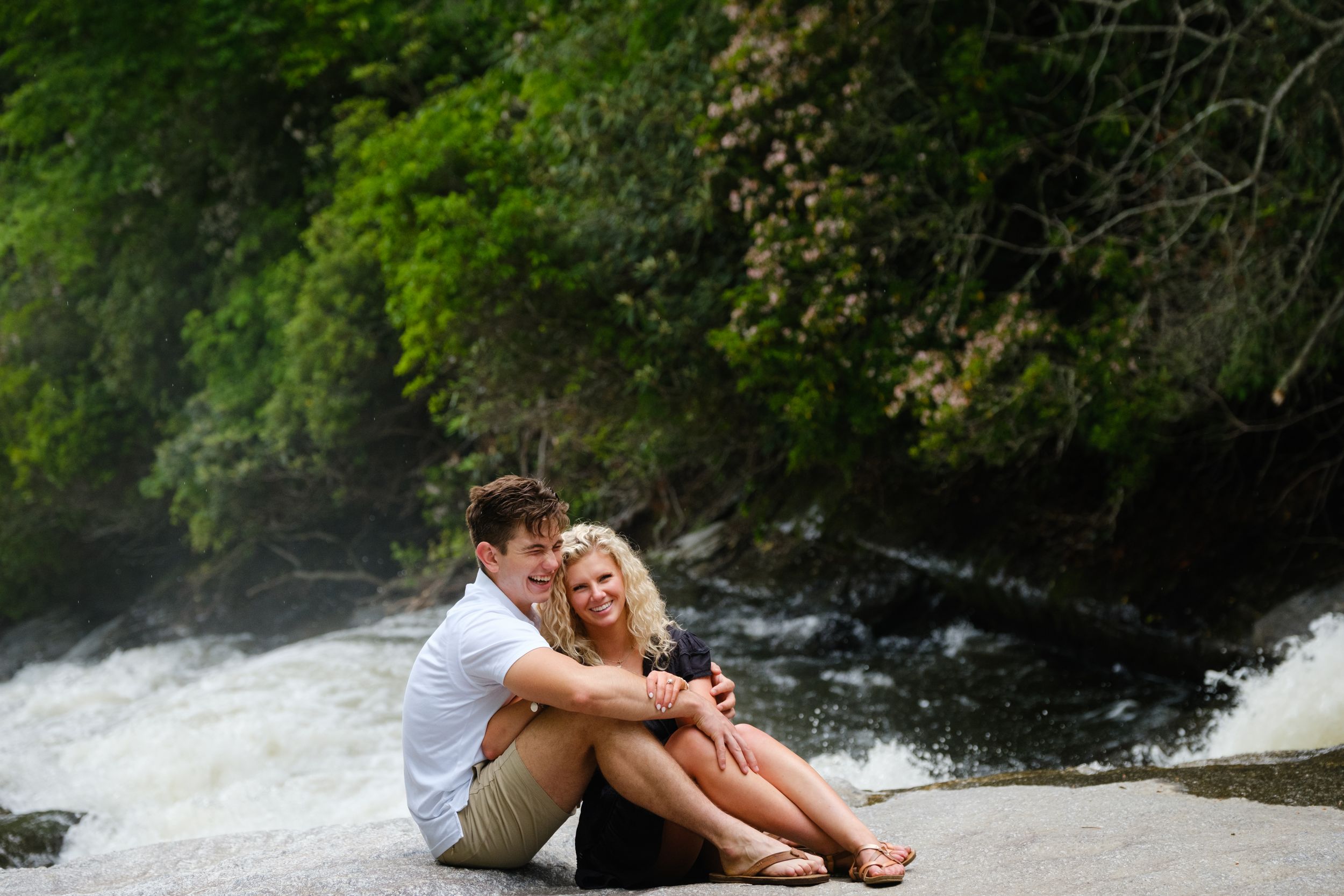 Adventure proposal portraits sitting on rocks above Rainbow Falls