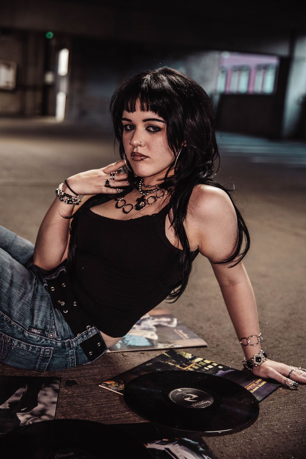 Girl sits in a parking garage for moody, cinematic, urban, portrait, senior photos in Denver, Colorado outside, urban, and nature photos