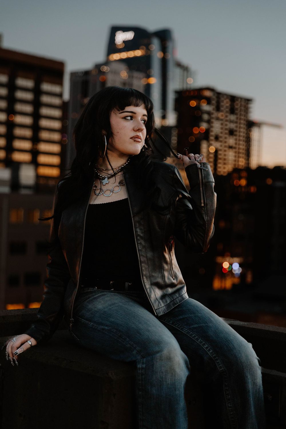 Girl sits on roof for moody, cinematic, urban, portrait, senior photos in Denver, Colorado outside, urban, and nature photos