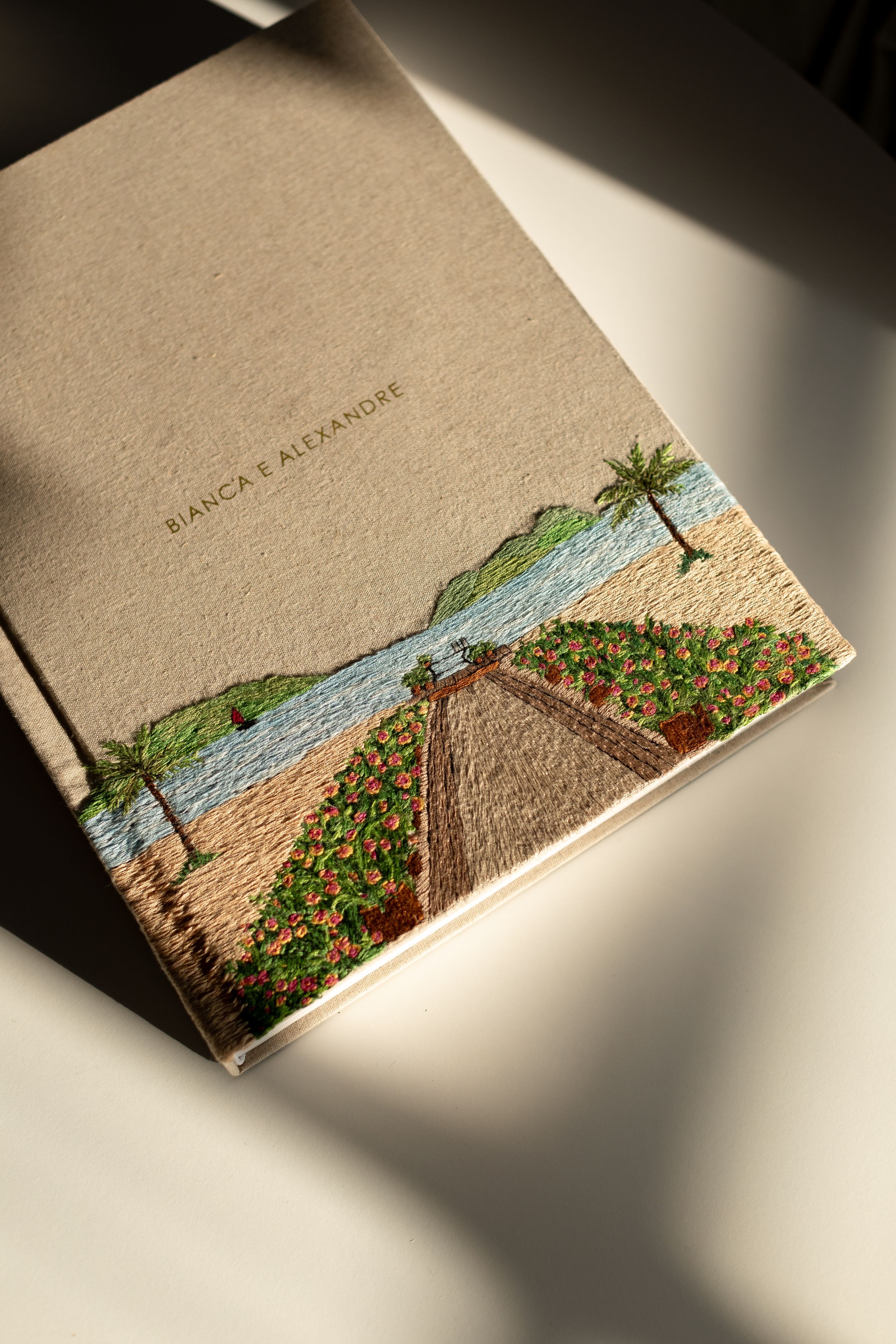 A series of multilayered paper cards displaying a cottage scene with mountains and lake viewed from varying angles in dim light.