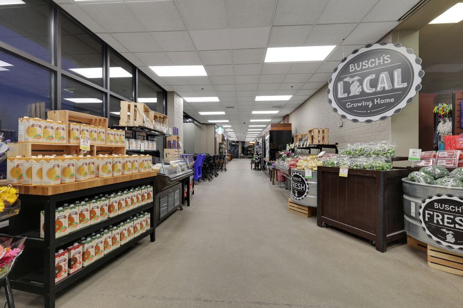 Busch's Local grocery store aisle featuring fresh produce and specialty food products under bright fluorescent lighting.