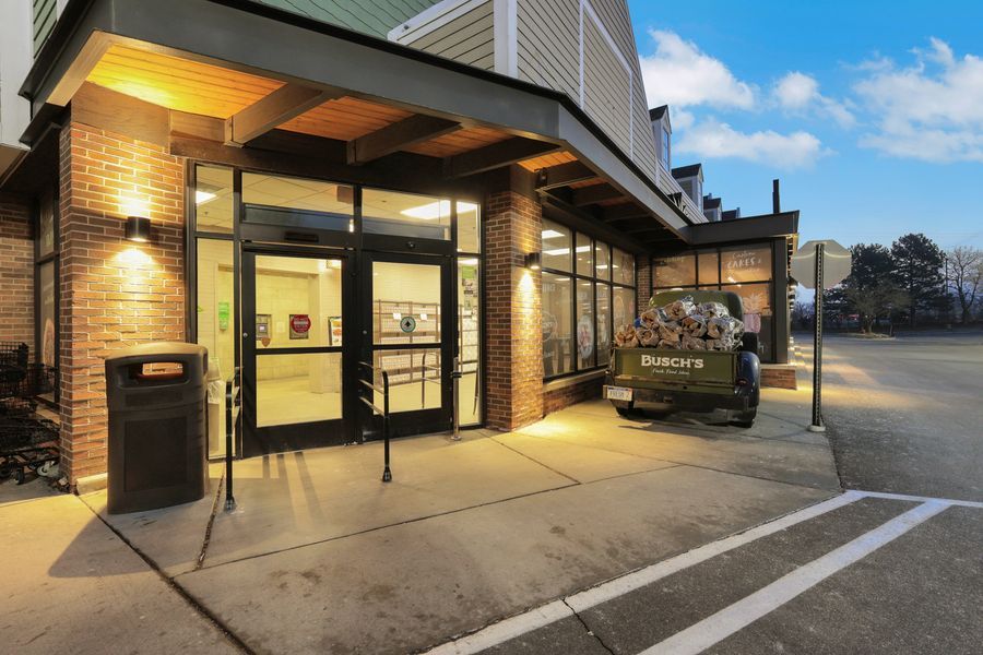 Exterior entrance of a Starbucks location at dusk with brick facade and glass doors.
