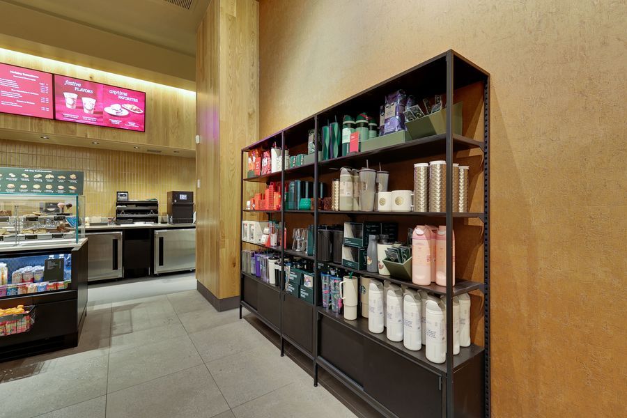 Modern retail display shelves stocked with colorful coffee products and supplies in a Starbucks store.