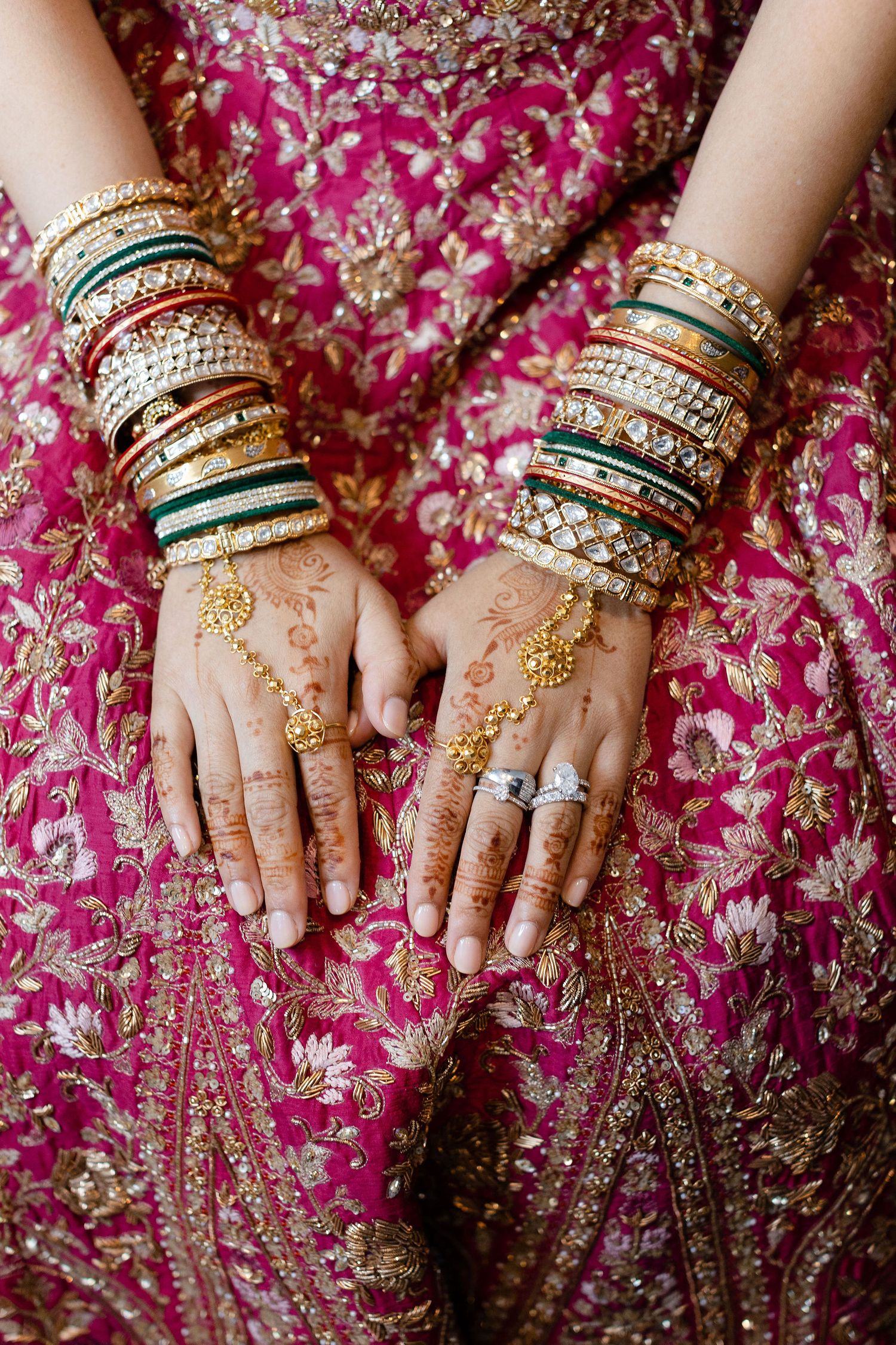 Hindu bride's hands closeup showing luxury jewellery and intricate henna details