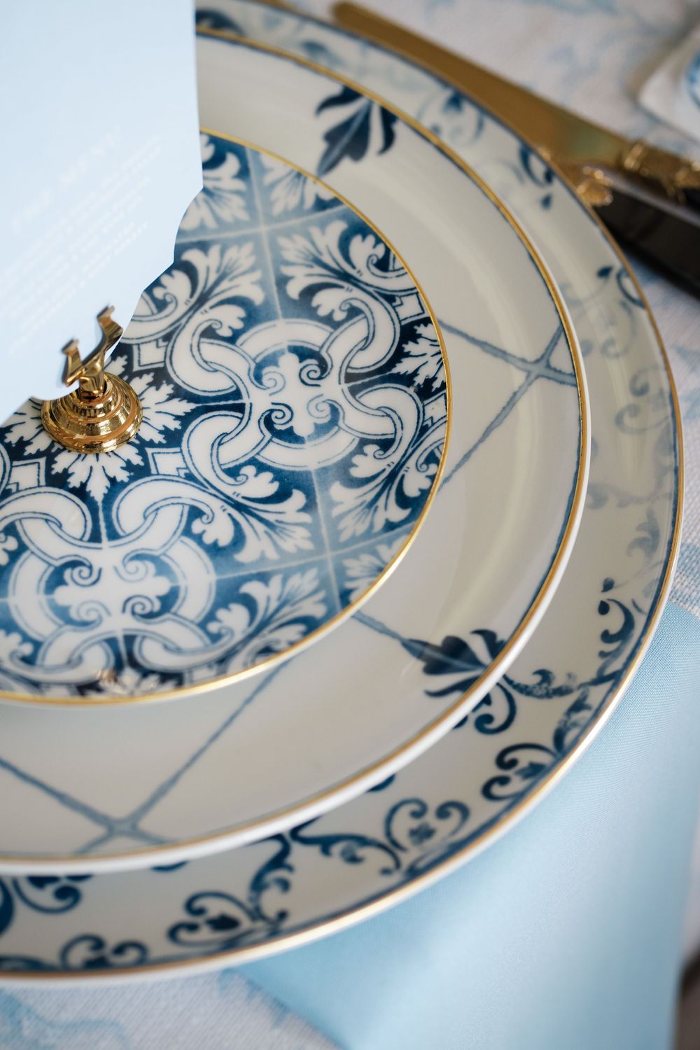 Close-up of blue and white china place setting with delicate gold accents.