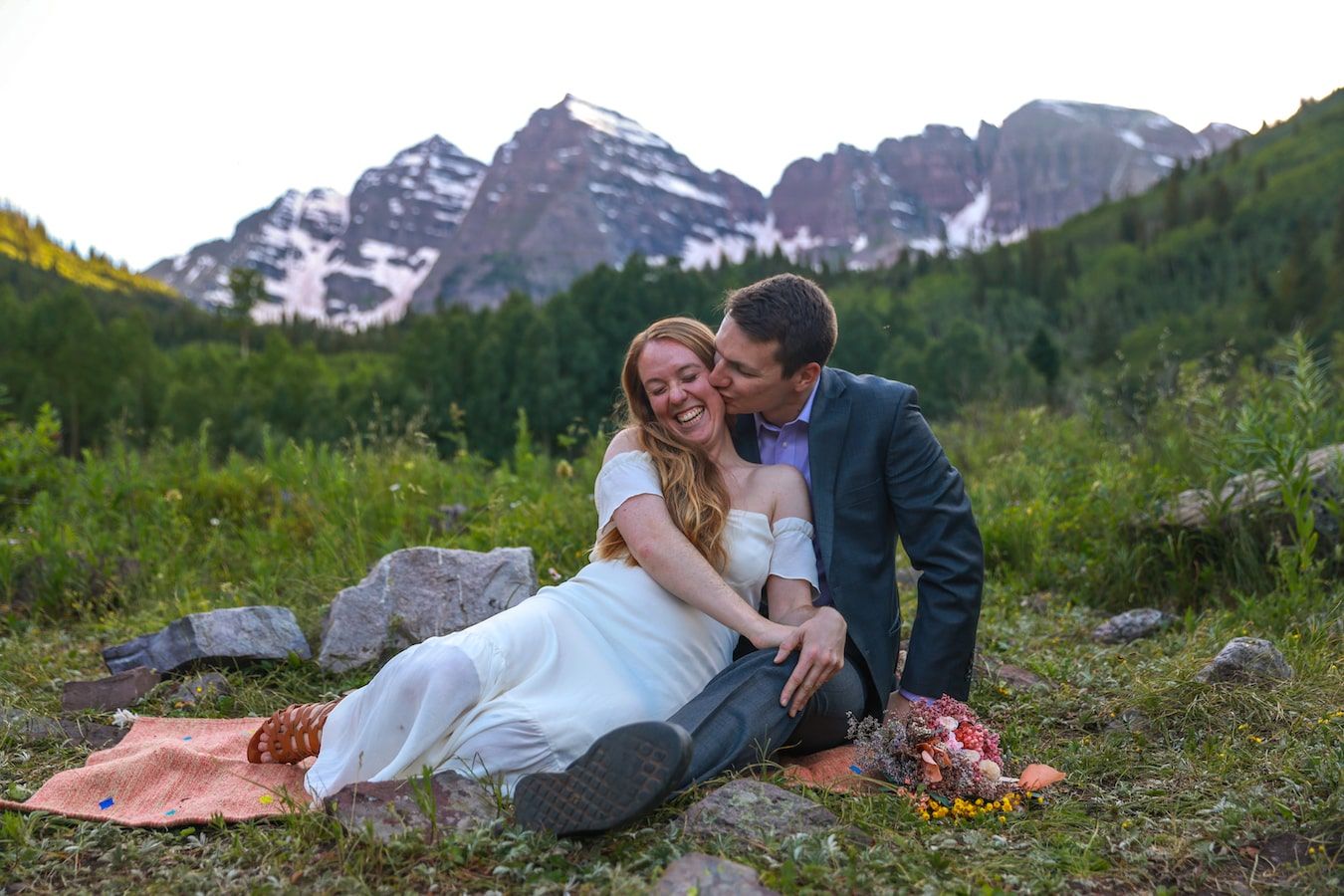 romantic couple on a grass with Mountain View backdrop in colorado