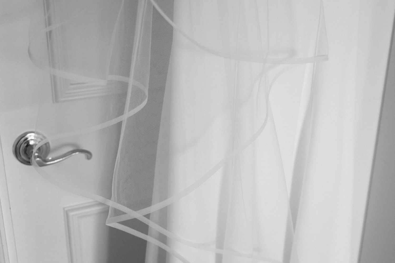 Sunlit wedding ceremony in progress with a stunning white wedding dress and veil in the foreground.