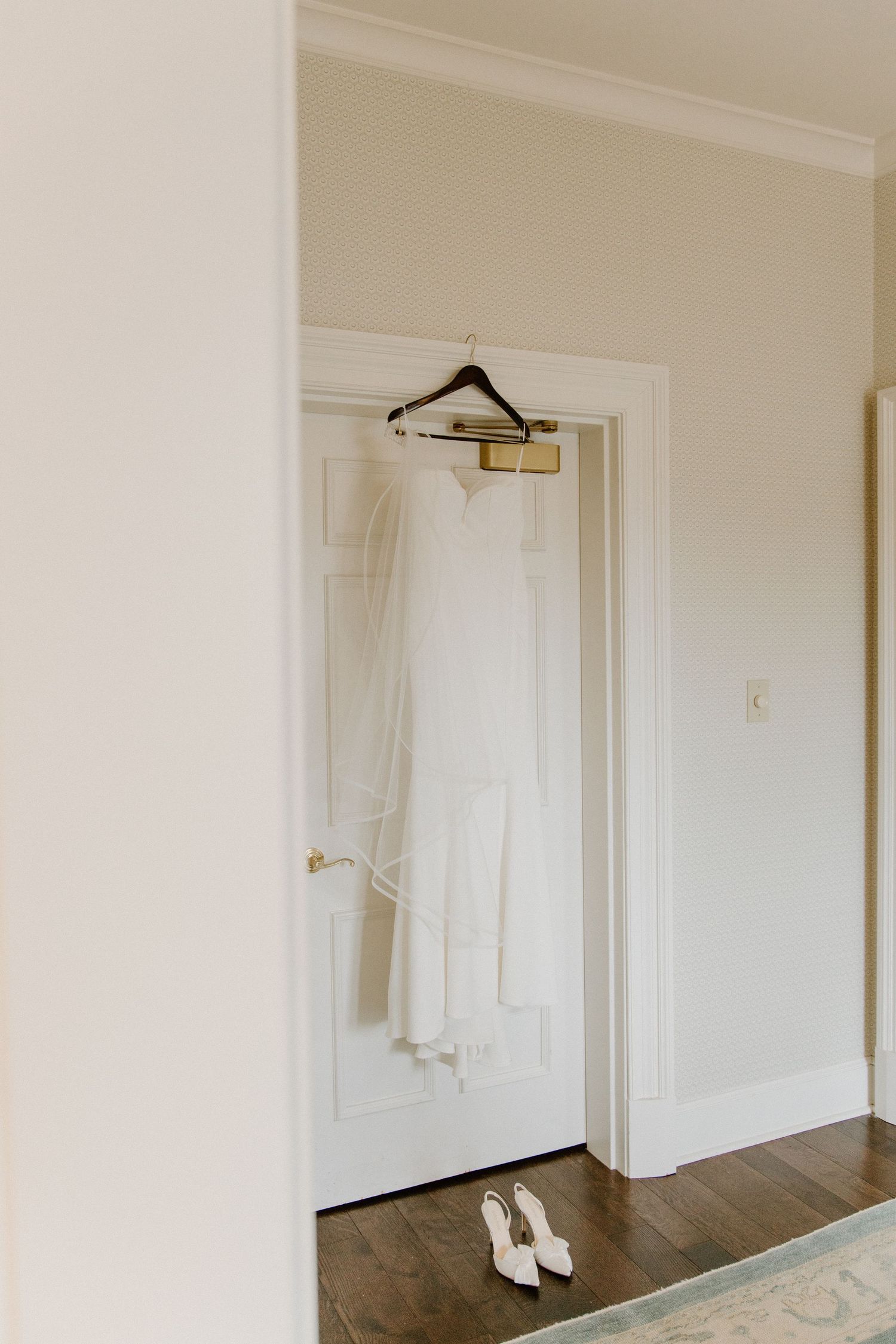 Three identical white interior doors with gold handles and trim mounted on a beige wall with dark hardwood flooring.