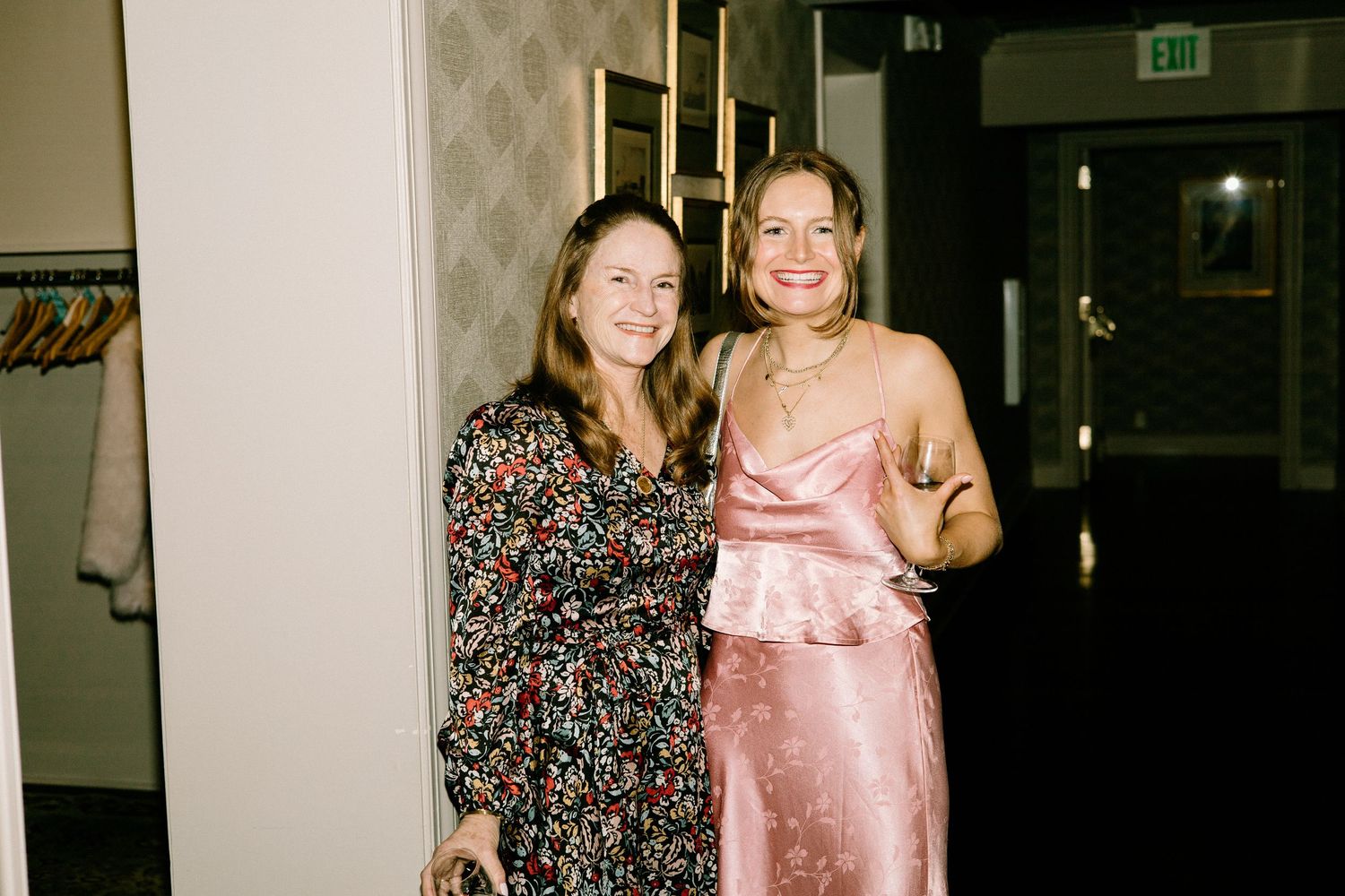 People in formal attire pose together at what appears to be an evening event or celebration.