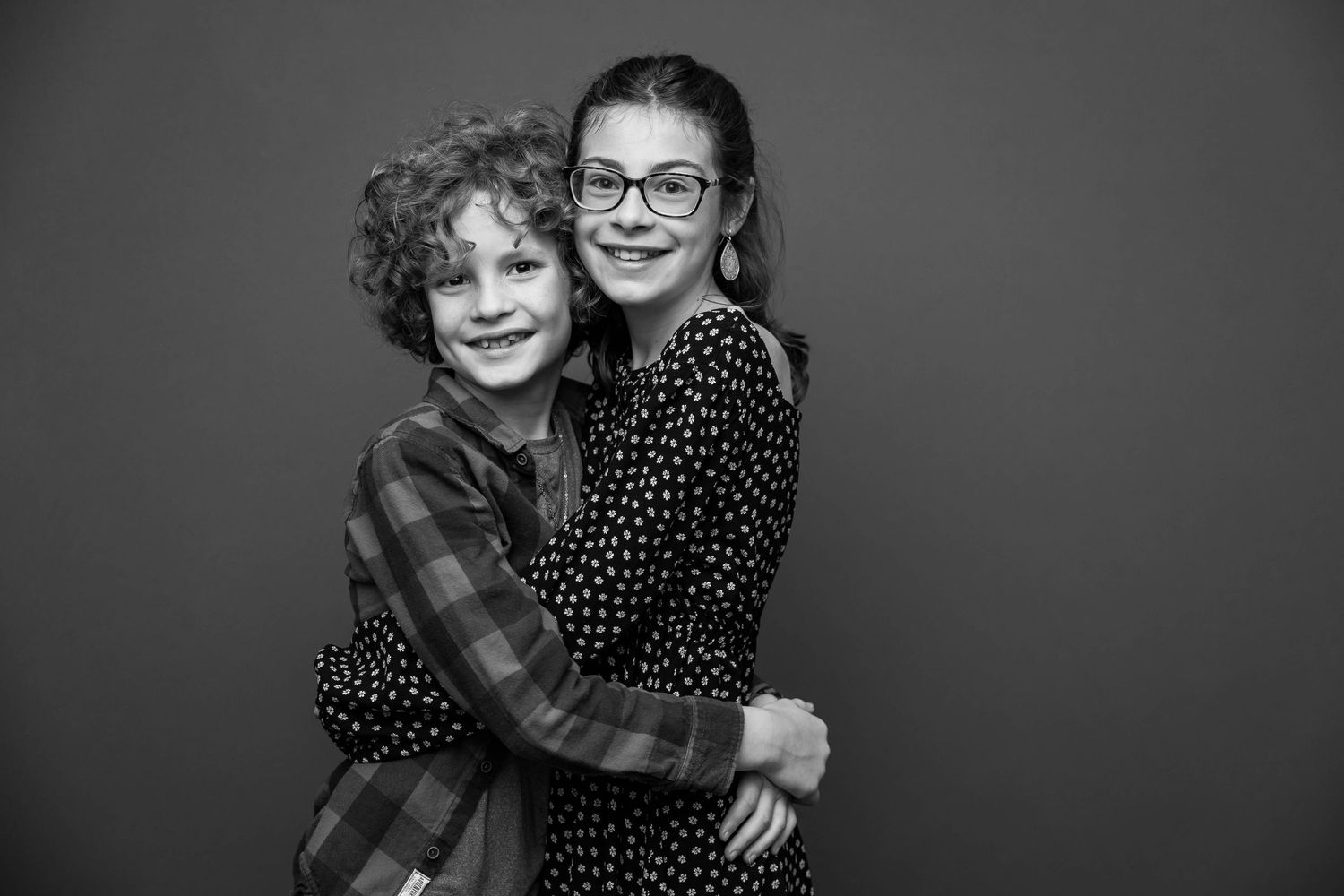 Two people snuggling and smiling together in a black and white candid photo series.