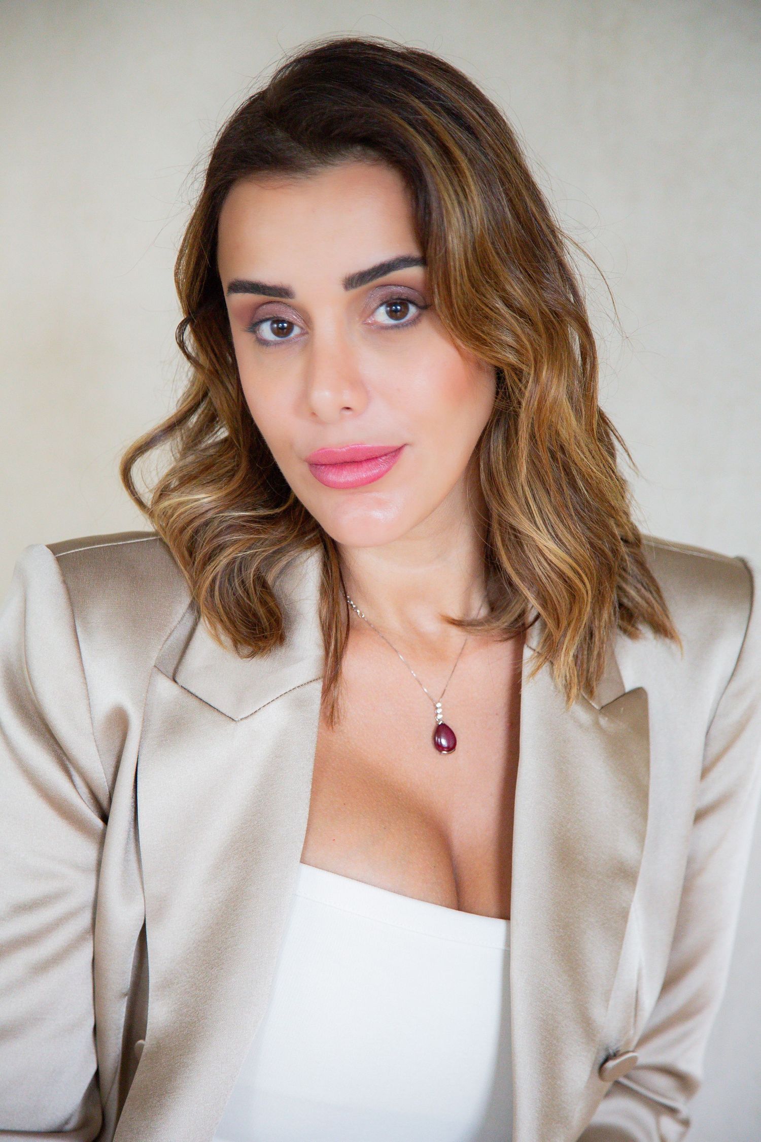 Close-up portrait series featuring beige blazer and statement necklace styling.