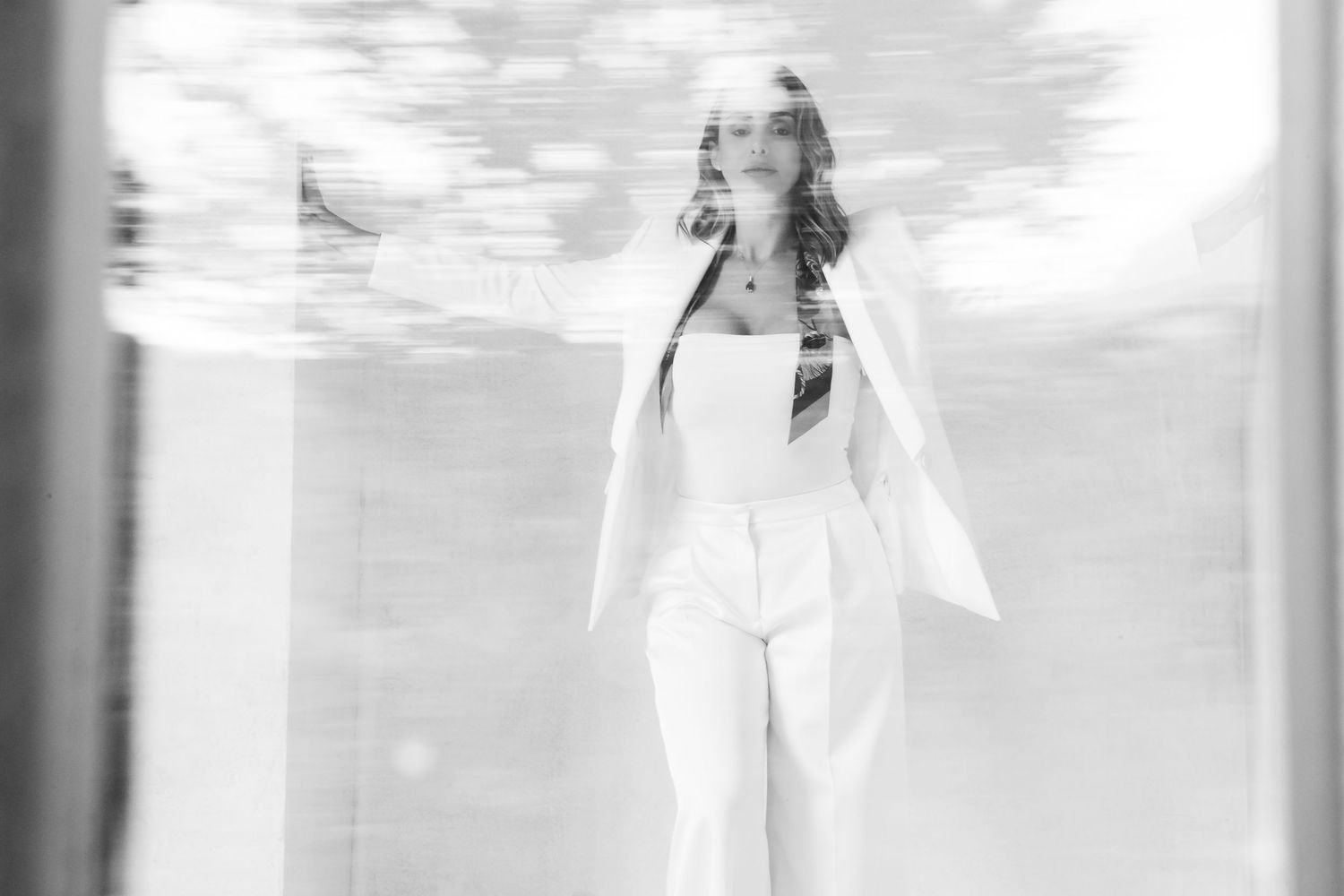 Dreamy black and white photo of someone in white attire with ethereal lighting effects.