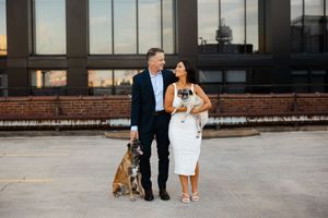 A couple walks along an outdoor brick pathway in formal attire as they share romantic moments at sunset.