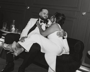 Groom lifting the bride during their wedding celebration at The Coffee Grind in Massapequa