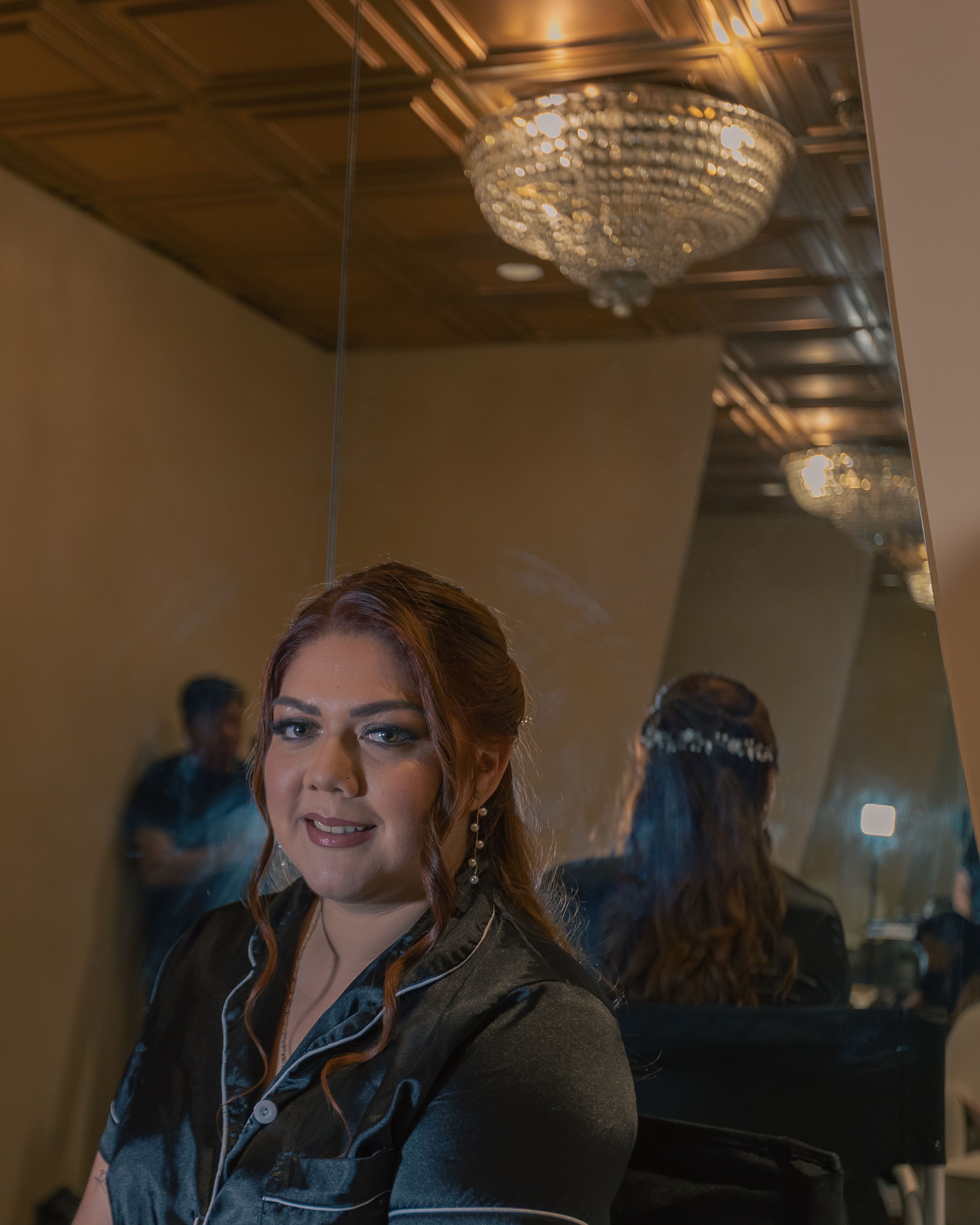 Interior shots of person in dark pajamas with glamorous makeup under warm lighting.