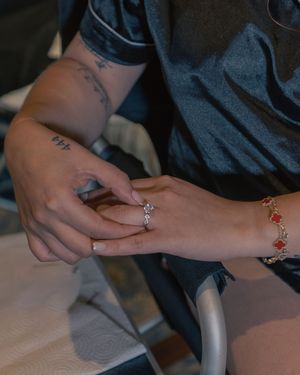 Close-up of hands with French manicure and delicate jewelry.