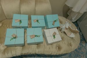 Row of turquoise gift boxes arranged on cream-colored surface.