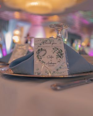Wedding place settings with decorative name cards and folded napkins on elegant tables.