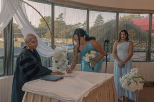 Wedding reception venue with tables set up and natural light streaming through large windows.