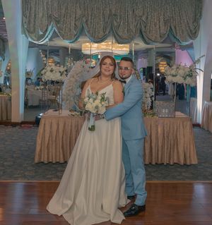 A wedding couple posing in front of elegant decor at their reception venue.