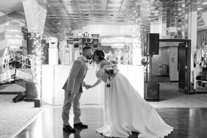 A black and white photo of a couple sharing a romantic moment during their wedding reception.