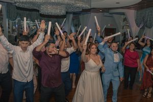 Celebration on dance floor with guests raising their hands in joyful moment.