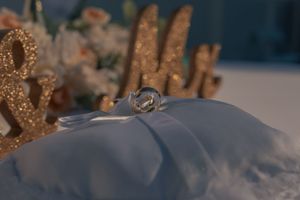 Glittering gold wedding decor arranged on white tablecloth.
