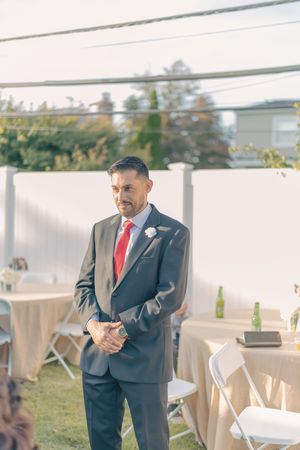 Outdoor wedding venue setup with white chairs and natural lighting.