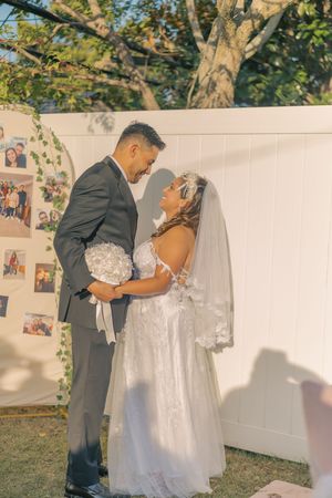 Romantic wedding photoshoot against white backdrop with trees in background.