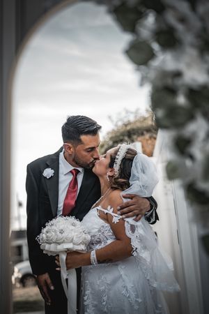 Romantic dip kiss captured during outdoor wedding photoshoot.