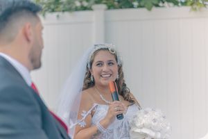A couple shares an emotional moment during their wedding ceremony with joyful expressions.