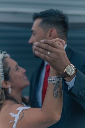 A tender moment between newlyweds showing rings and embracing.