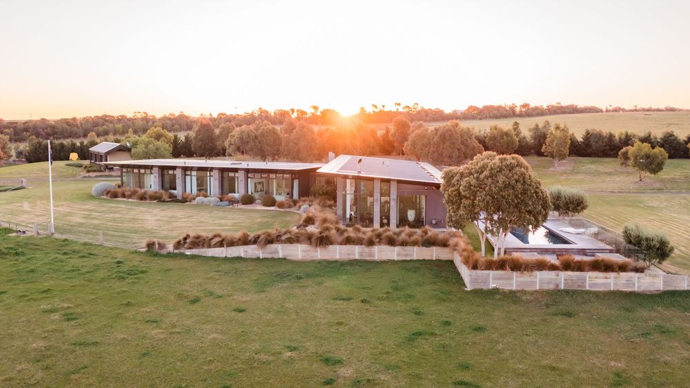 Wide aerial view of countryside property development at golden hour.