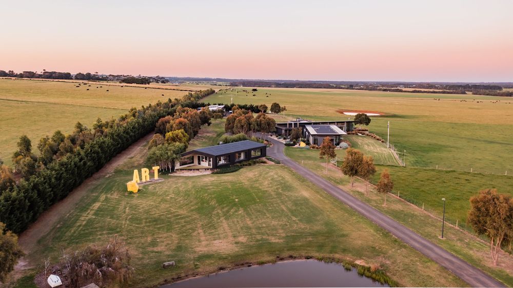Sunset aerial view showing sprawling residential development in countryside setting.
