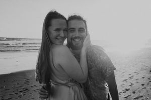 Couple enjoying a romantic moment together on a sandy beach during sunset.