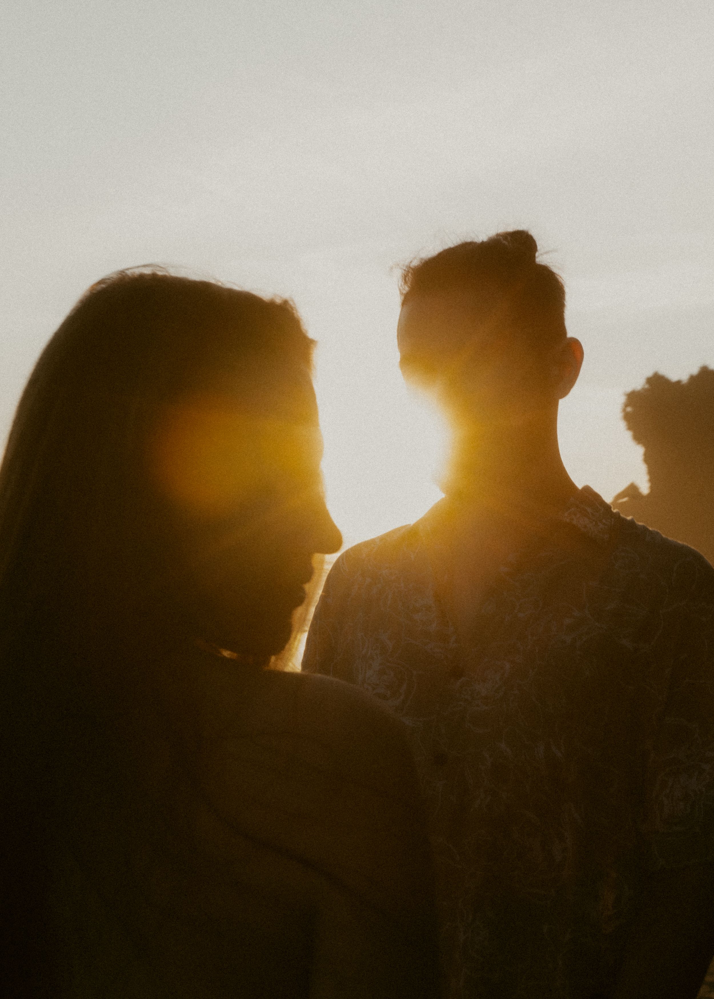 Silhouettes of people standing in a row against a bright golden sunset sky.