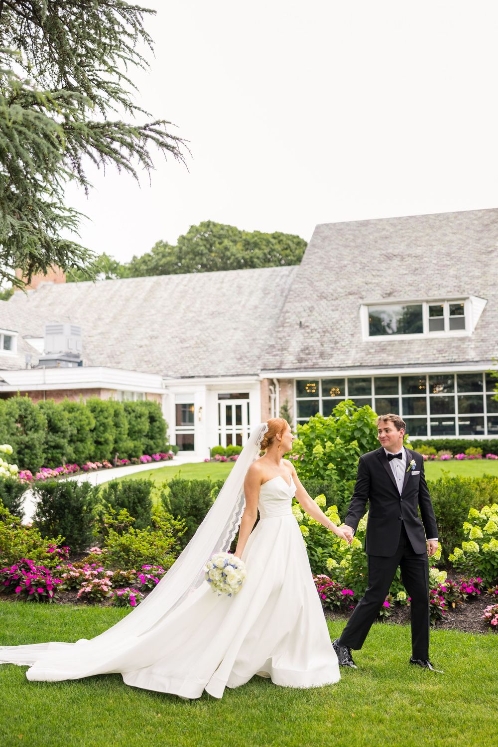 Bride and groom share playful moments in a garden setting with lush greenery and pink flowers, captured in multiple poses.