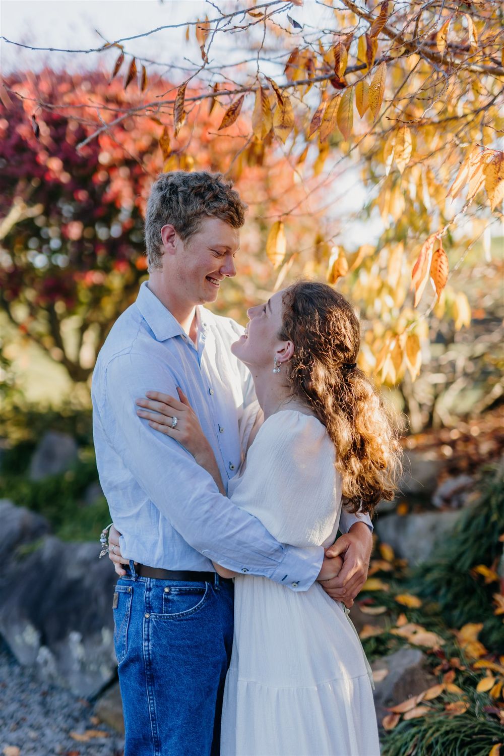 Giorgia and Peter hugging at their engagement session while Charlotte Rowlands photographs them