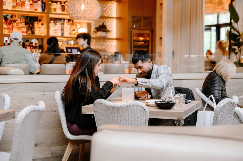 Modern restaurant interior with warm lighting and white seating arrangements shows an intimate dining atmosphere.