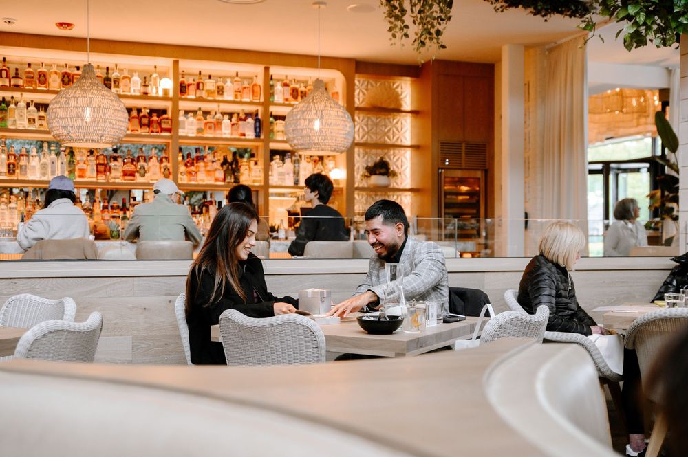 Contemporary restaurant with white decor, hanging plants, and ambient lighting creating a sophisticated atmosphere.