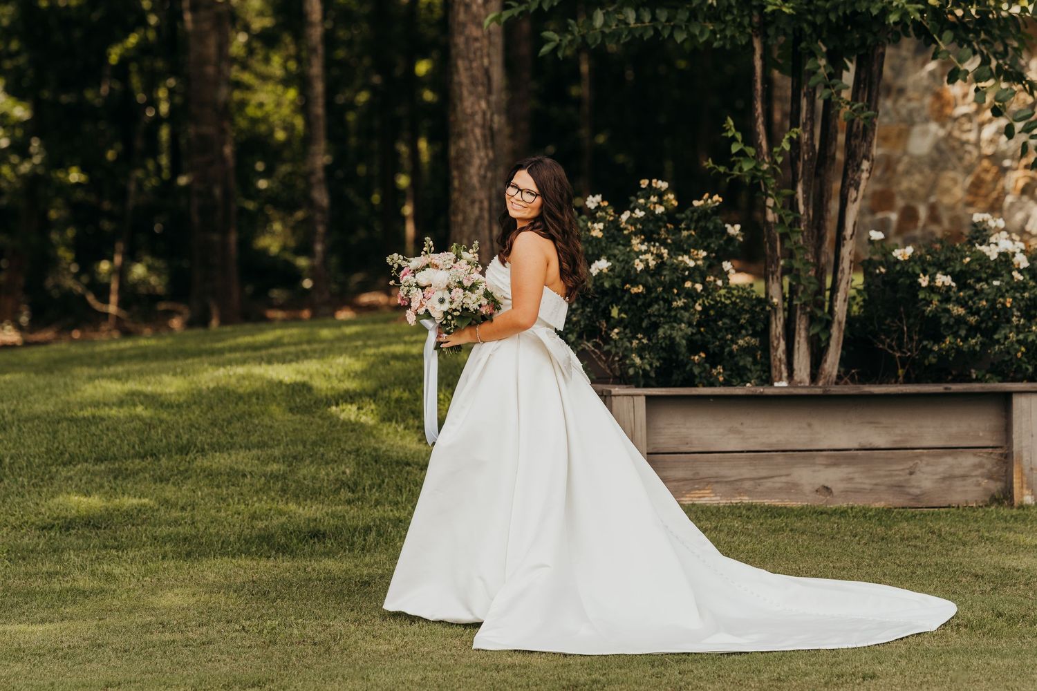 Elegant bridal scene with a white ballgown wedding dress in a lush garden setting during golden hour in East Texas.