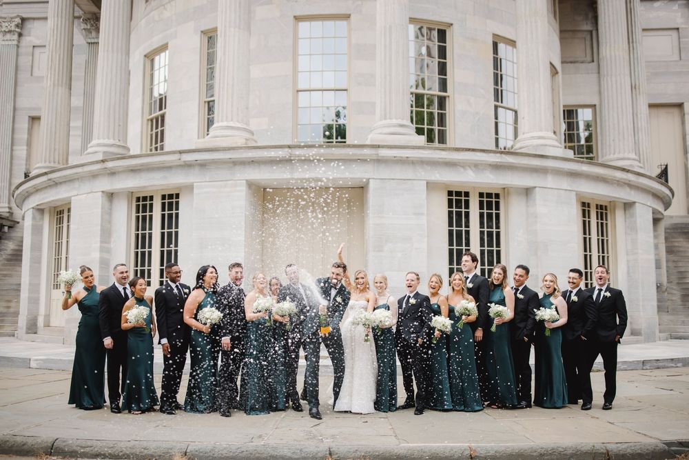 Wedding party celebrates with champagne at the Merchant Exchange in Philadelphia — a grand and timeless backdrop for elegant city weddings.