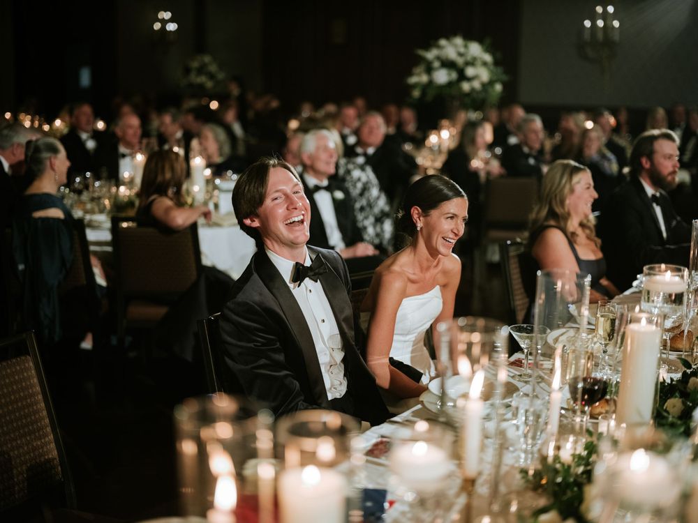 Candid reception moment at the Union League in Philadelphia, with newlyweds laughing among elegant candlelit tables and guests.