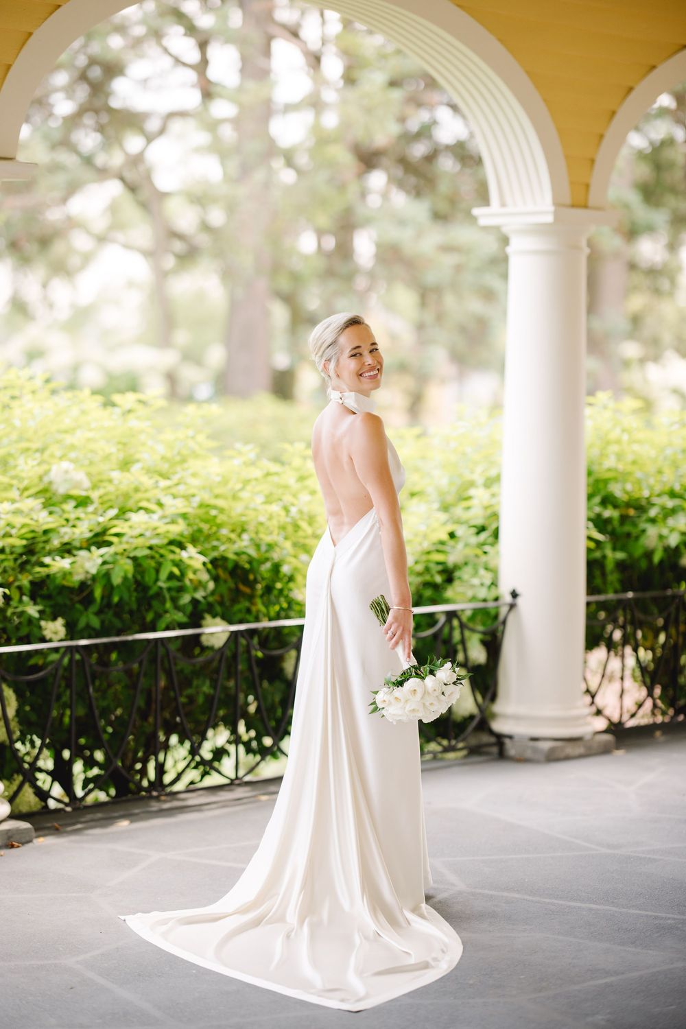 Bride posing under elegant arches at Philadelphia Cricket Club, showcasing her timeless gown and serene wedding day moment.