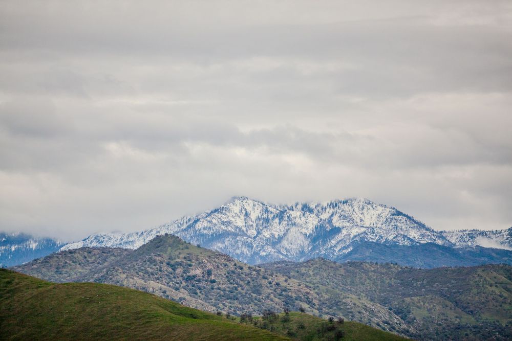 Snow-capped mountain peaks stretch across a cloudy horizon.