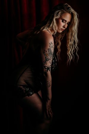 Artistic boudoir photograph with moody dark lighting features black lingerie and tattoos in a glamour portrait. grand rapids boudoir, MI