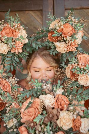 Close-up of peach roses and greenery floral arrangement creating romantic wedding details.